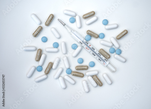 pills and thermometer isolated on white background