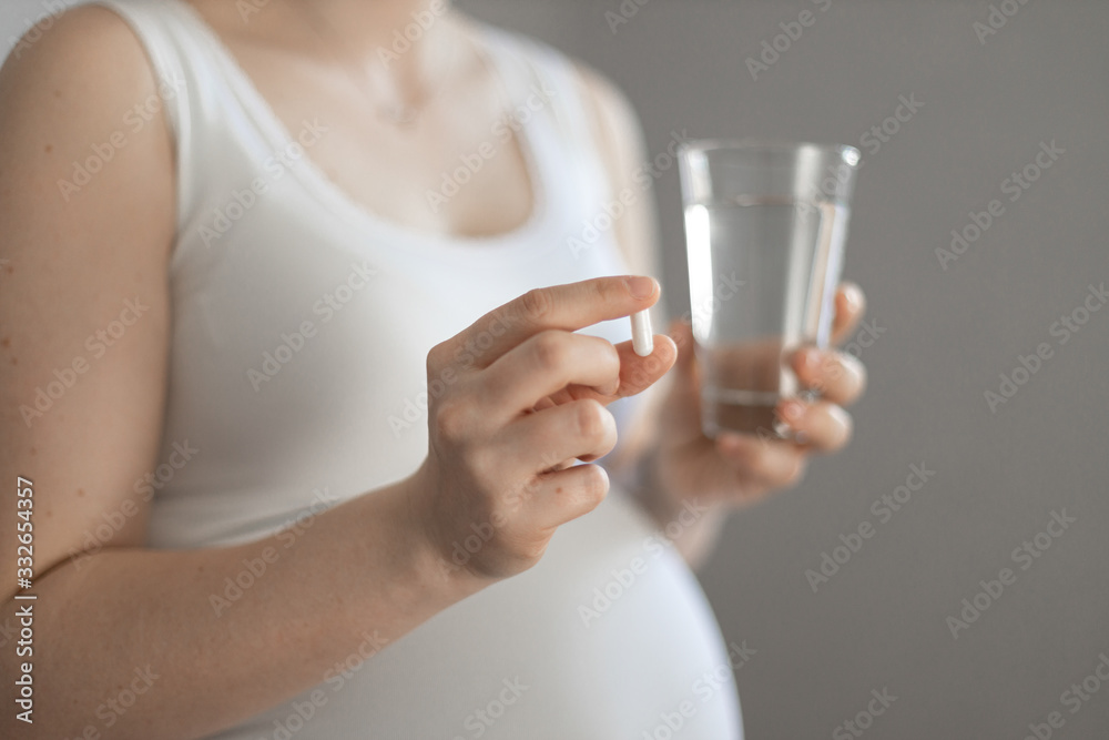 pregnant woman taking white pills, very close pregnant woman taking white pills, very close