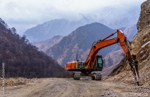 Excavator crushes stones in the mountains