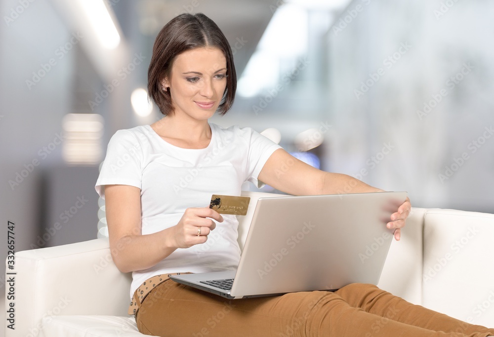 Young pretty woman relaxing on a couch with a laptop in the living room. Young pretty woman relaxing on a couch with a laptop in the living room.