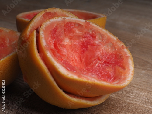 Obraz na plátně half of squeezed pink grapefruit on wood background