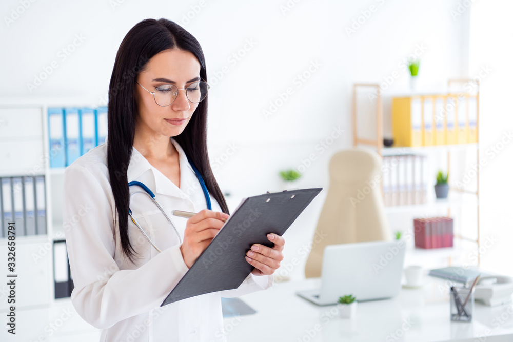 Photo of beautiful professional doc lady intern hold hands clipboard writing patient prescription wear specs stethoscope white lab coat standing office clinic indoors Photo of beautiful professional doc lady intern hold hands clipboard writing patient prescription wear specs stethoscope white lab coat standing office clinic indoors