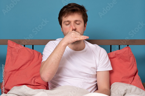 man breathing Alternate Nostril Breathing exercise, working outsitting in bed photo