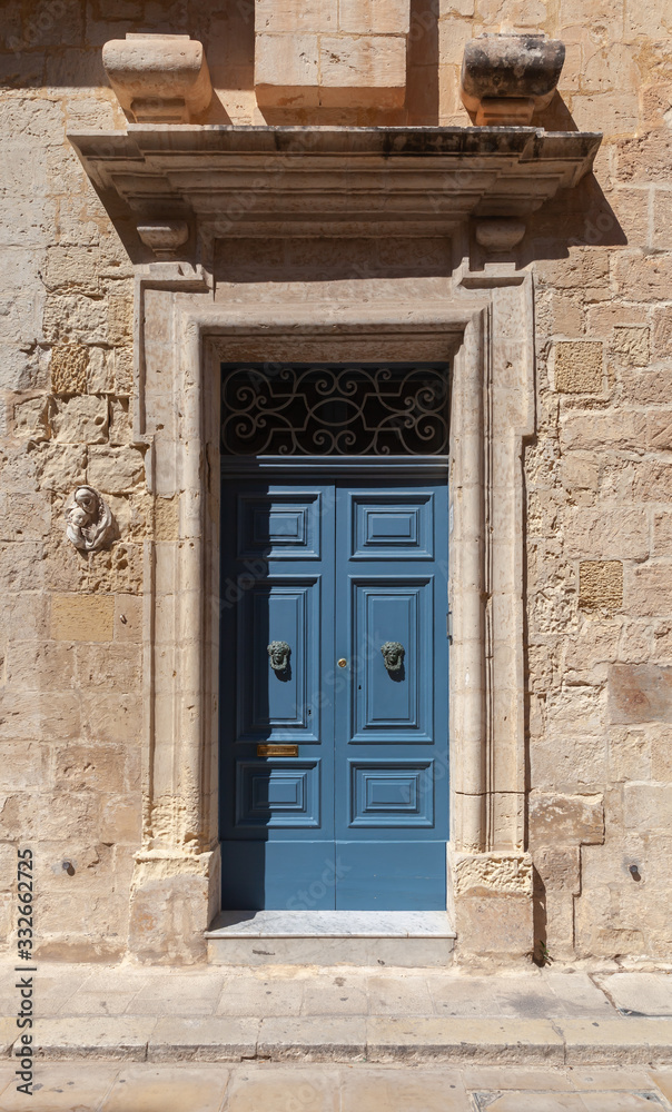 Vintage blue wooden door in yellow stone wall