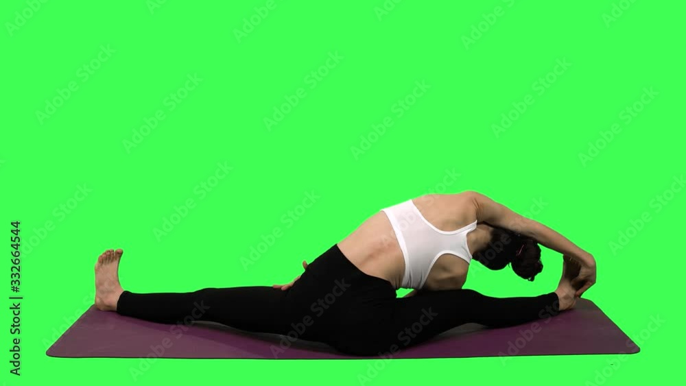 Flexible Athletic Woman Stretching Before Or After a Workout Over Green Screen. From The Back. Flexible Athletic Woman Stretching Before Or After a Workout Over Green Screen. From The Back.