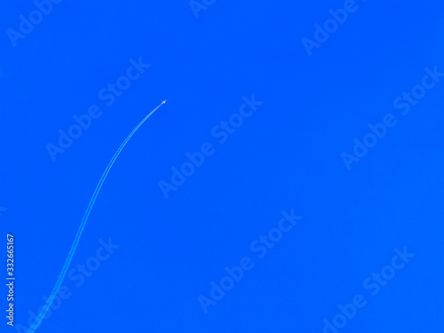 Airplane upwards and trail in clear blue sky