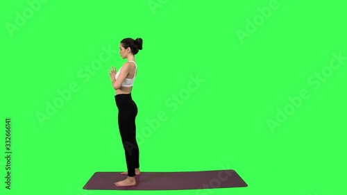 Extremely flexible woman practice a series of various positions, over green screen. Long shot. photo