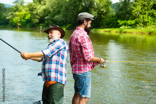 Father and adult son fishing in lake. Family time. Man bearded fisher. Fishing team. Big game fishing. Retired bearded fisher. Keep calm and fish on. I am happiest man. Friends fishing.