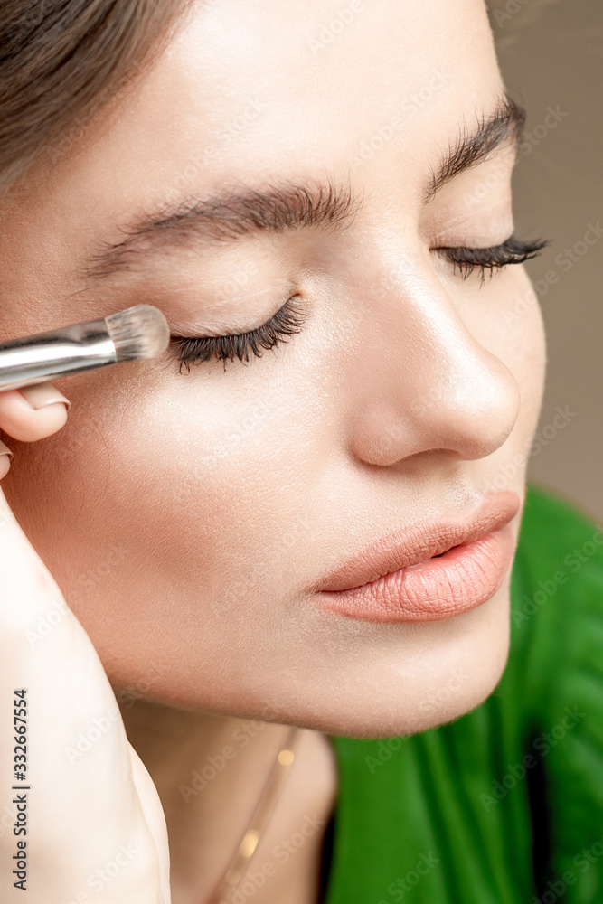 Woman applying eyeshadow powder.