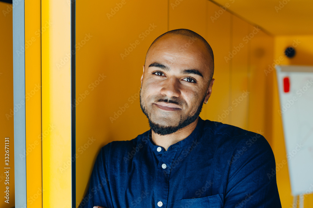 Obraz premium Happy african american businessman entrepreneur startup owner stand in modern office looking at camera, smiling young black designer creative person posing in work space