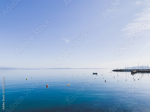 Blue sea and sky background, silhouette of lonely boat