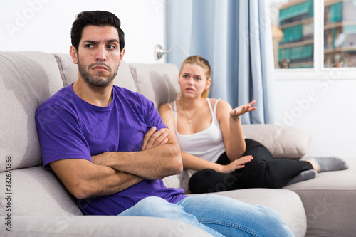 Upset man on sofa with disgruntled woman