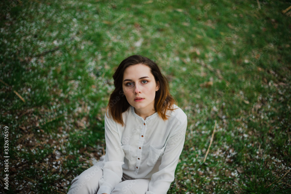 Beautiful young girl is resting and enjoying spring in the spring park Beautiful young girl is resting and enjoying spring in the spring park
