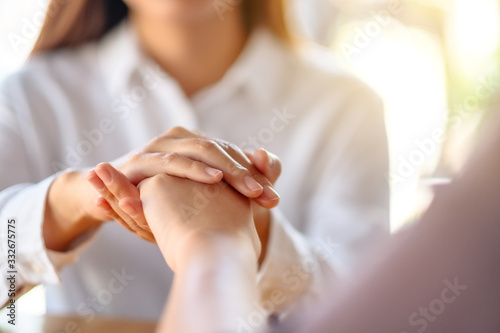 Women holding each other hands for comfort and sympathy