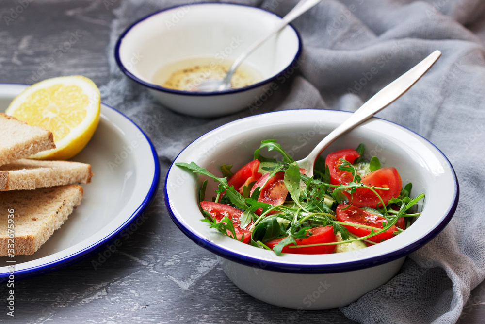 Salad with arugula, tomatoes, cucumbers and lemon sauce. Salad with arugula, tomatoes, cucumbers and lemon sauce.