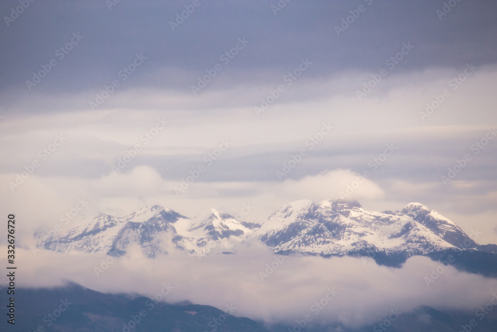 Snowy mountains emerging from the clouds