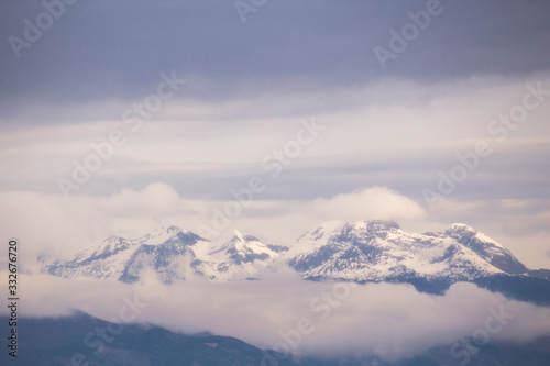 Snowy mountains emerging from the clouds