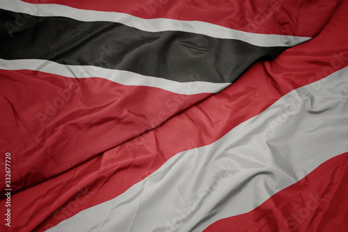 waving colorful flag of austria and national flag of trinidad and tobago.