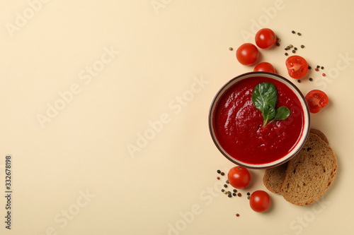 Tomato cream soup on beige background, top view