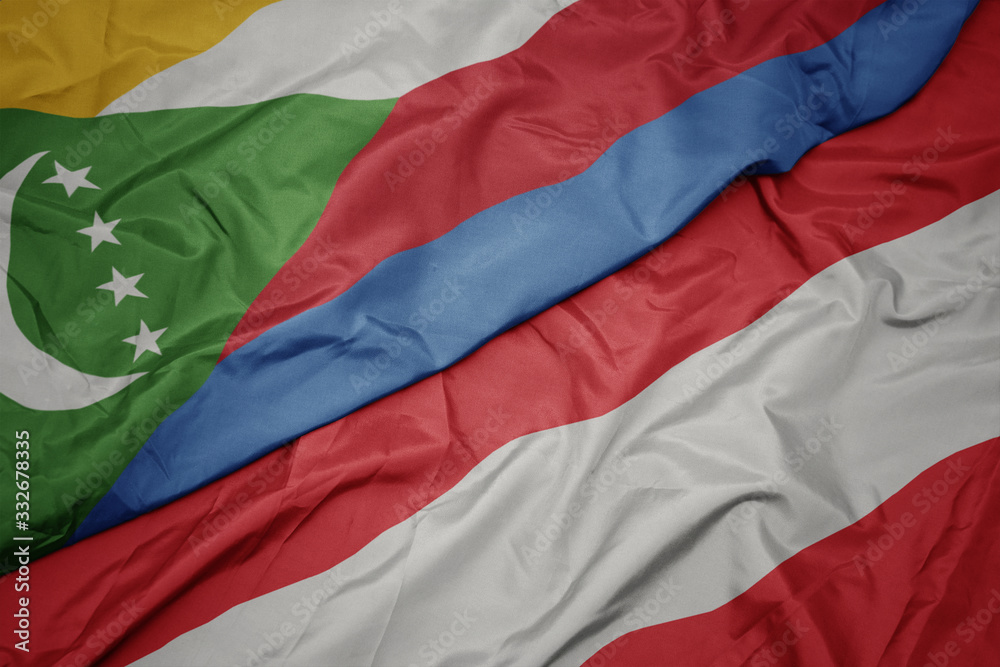 waving colorful flag of austria and national flag of comoros.