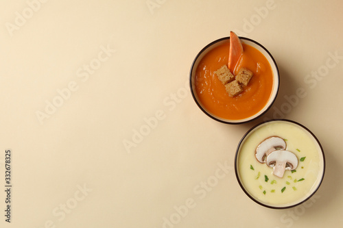 Vegetable soups on beige background, top view