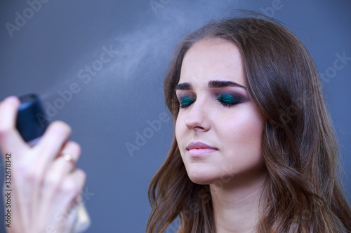 Obraz na plátne Fixing makeup with a spray