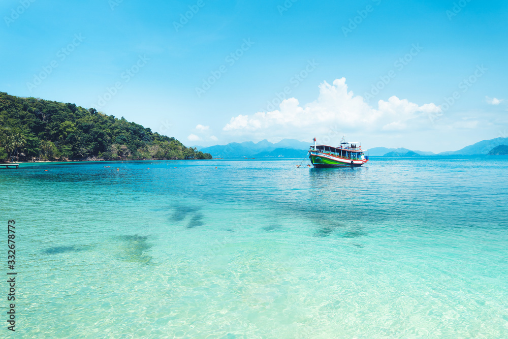 Clear water on the island,Bright blue sea and wooden boat The tourism