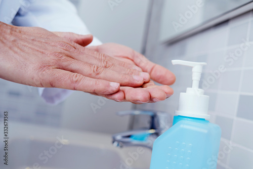 doctor disinfecting his hands with hand sanitizer