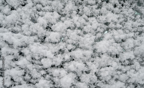Snow on glass surface. Natural texture background.
