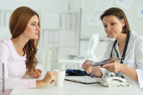 Portrait of woman in hospital with caring doctor