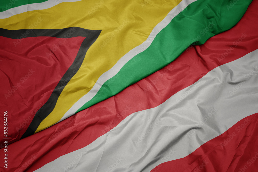 waving colorful flag of austria and national flag of guyana.