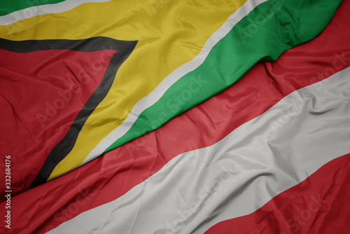 waving colorful flag of austria and national flag of guyana.