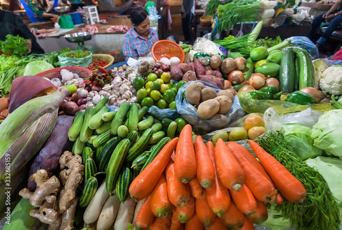 Carrot, ginger, onion. mango, greens, zucchini, pepper on the counter vegetable market of asian city
