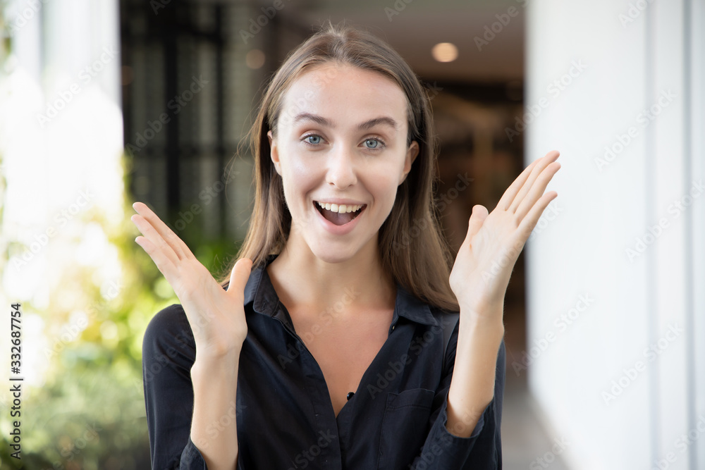 face portrait of excited surprised smiling girl; portrait of happy smiling excited white caucasian girl expression excitement and looking at you with surprise; young adult white caucasian woman model