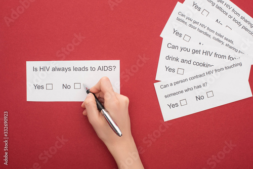 partial view of woman answering HIV questionnaire on red background