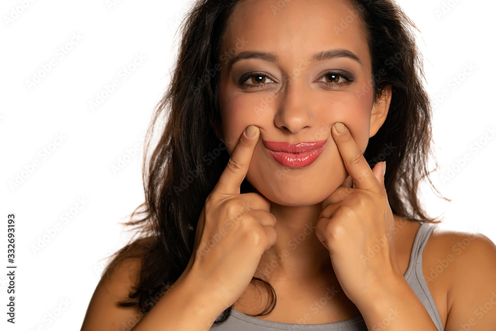 Young dark skinned woman forcing her smile with her fingers Young dark skinned woman forcing her smile with her fingers