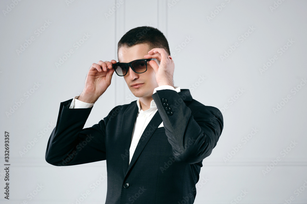 Young happy business man holding his hand on his sunglasses Young happy business man holding his hand on his sunglasses
