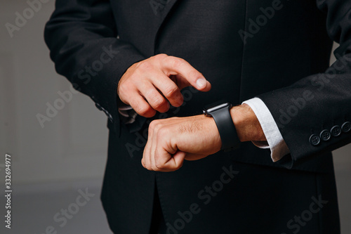 Young businessman pointing at smartwatch