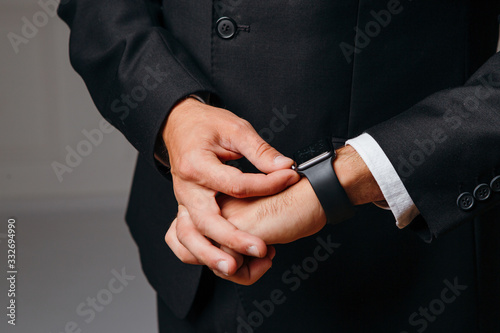 Young businessman adjusting watch on hand