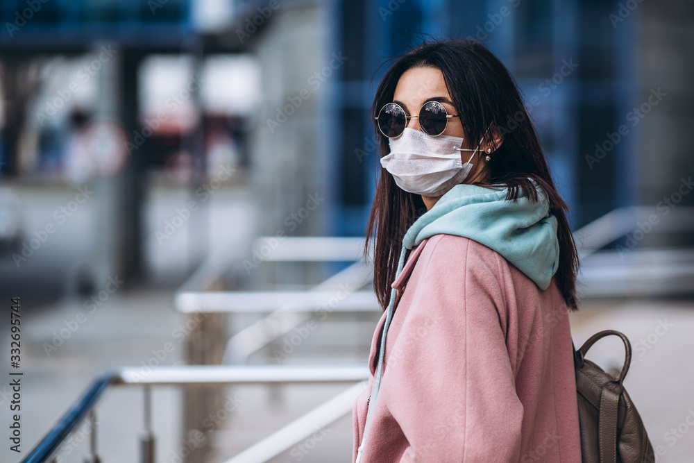Obraz premium Female in medical mask outdoors in the empty city. Health protection and prevention of virus outbreak, coronavirus, COVID-19, epidemic, pandemic, infectious diseases, quarantine concept.