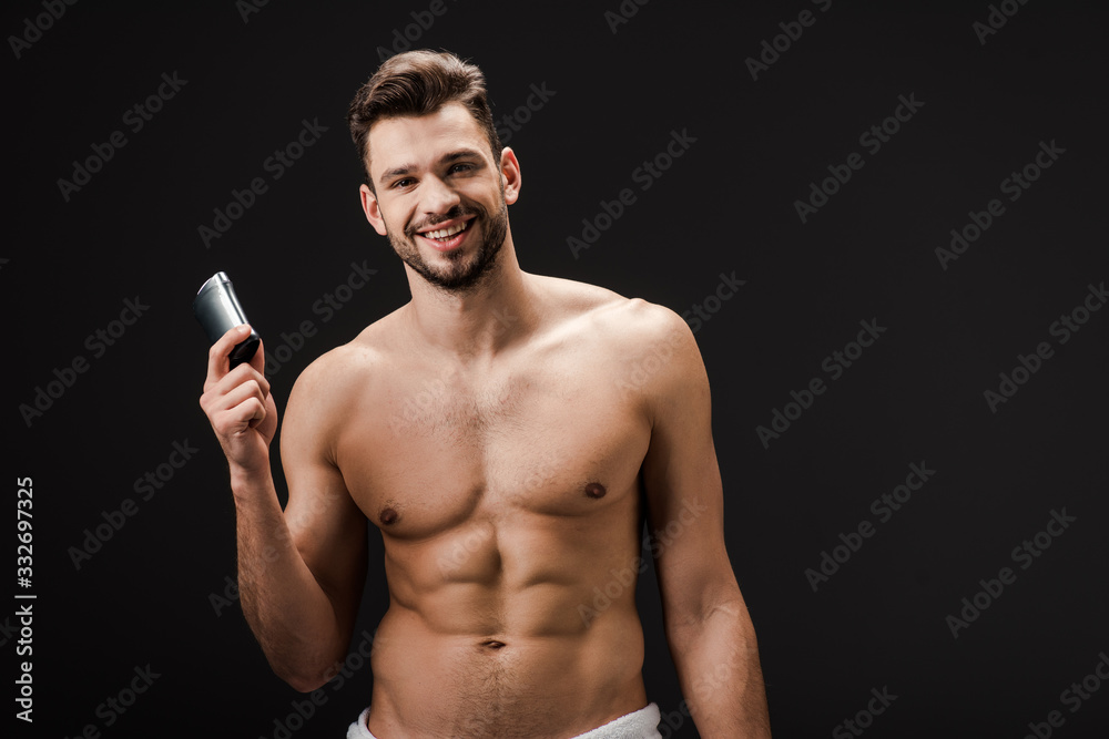 cheerful sexy man holding deodorant isolated on black cheerful sexy man holding deodorant isolated on black