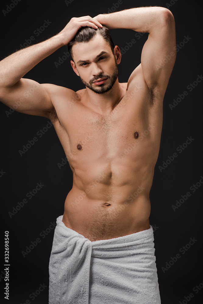 handsome sexy muscular man in towel isolated on black