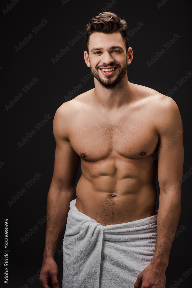 smiling sexy muscular man in towel isolated on black smiling sexy muscular man in towel isolated on black