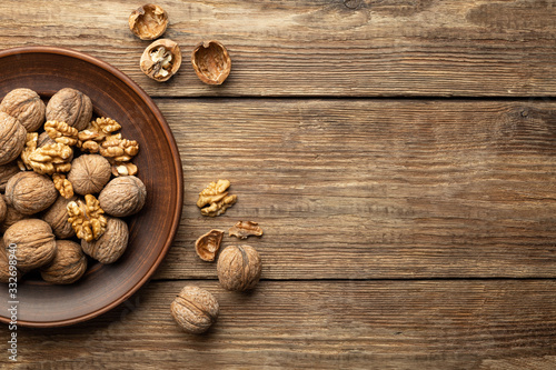 Nuts. Walnut kernels and whole walnuts on a table. Wooden background. Top view, flat lay with copy space.
