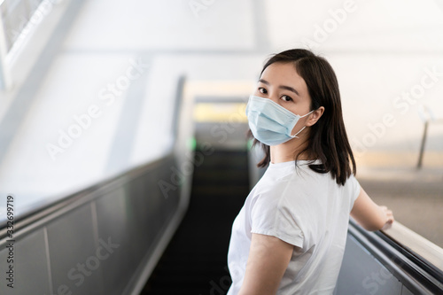 Woman wearing a hygiene protective mask to protect COVID19 virus and pm2.5 pollution while traveling in the crowded place. Woman use face mask to protect corona virus crisis in Asian country. Sickness