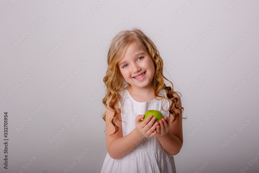 baby girl holding a green Apple smiling on a white background baby girl holding a green Apple smiling on a white background