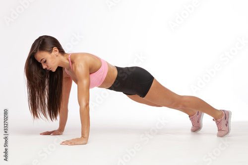 Beautiful brunette doing some push ups. Fitness woman doing push ups.