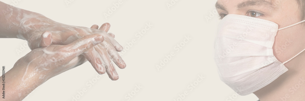 Corona virus. Young guy in a medical protective mask and washing his hands with soap on a gray background. Protection against viruses, infections. Corona virus. Young guy in a medical protective mask and washing his hands with soap on a gray background. Protection against viruses, infections.