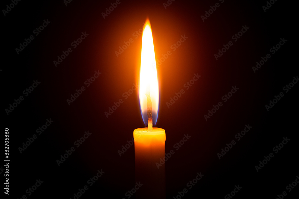 Red candle with yellow flame on black background Red candle with yellow flame on black background