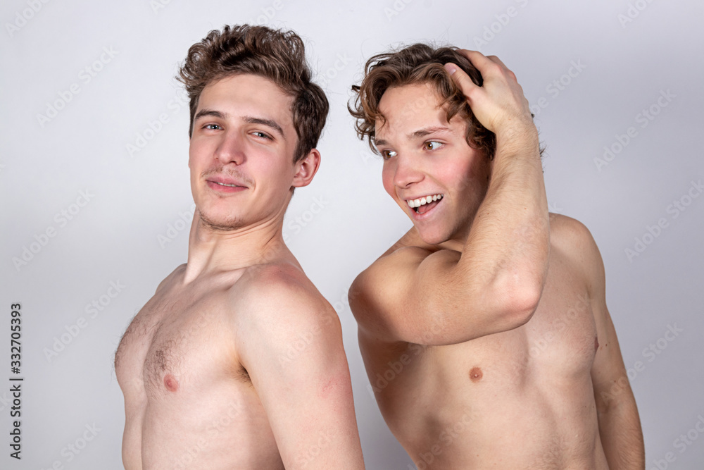 Two naked guys hugs on a white background. Love, passion and